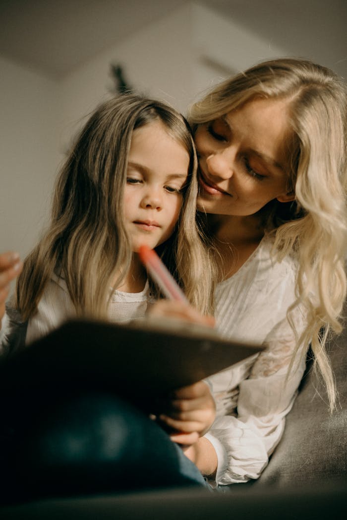 A loving mother and daughter bonding through art in a cozy setting.